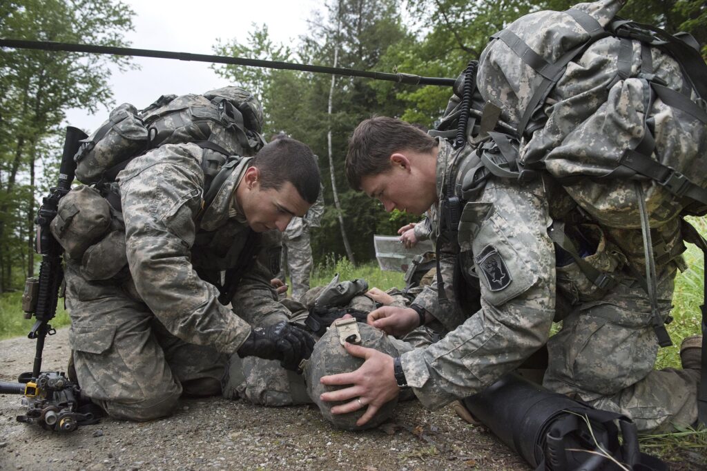 Soldiers work on helping a wounded soldier.